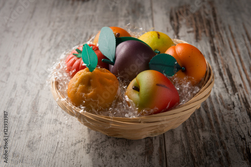 Frutta martorana tipica siciliana colorata in un cestino su un tavolo photo