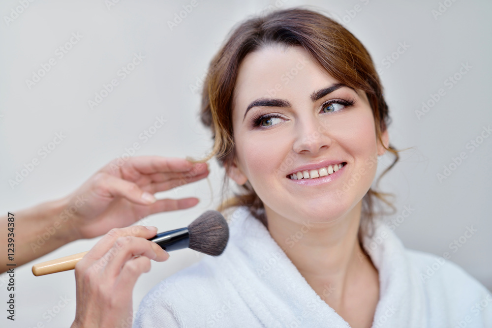 Wedding makeup artist making a make up for bride. Beautiful sexy model girl indoors. Beauty woman with curly hair. Female portrait. Bridal morning of a cute lady. Close-up hands near face Wedding makeup artist making a make up for bride. Beautiful sexy model girl indoors. Beauty woman with curly hair. Female portrait. Bridal morning of a cute lady. Close-up hands near face
