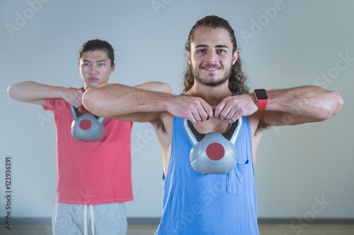 Men exercising with kettlebell