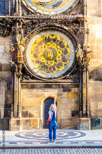 Photography Young female traveler refers to the astronomical clock in the Old Town Hall - the national symbol of Prague