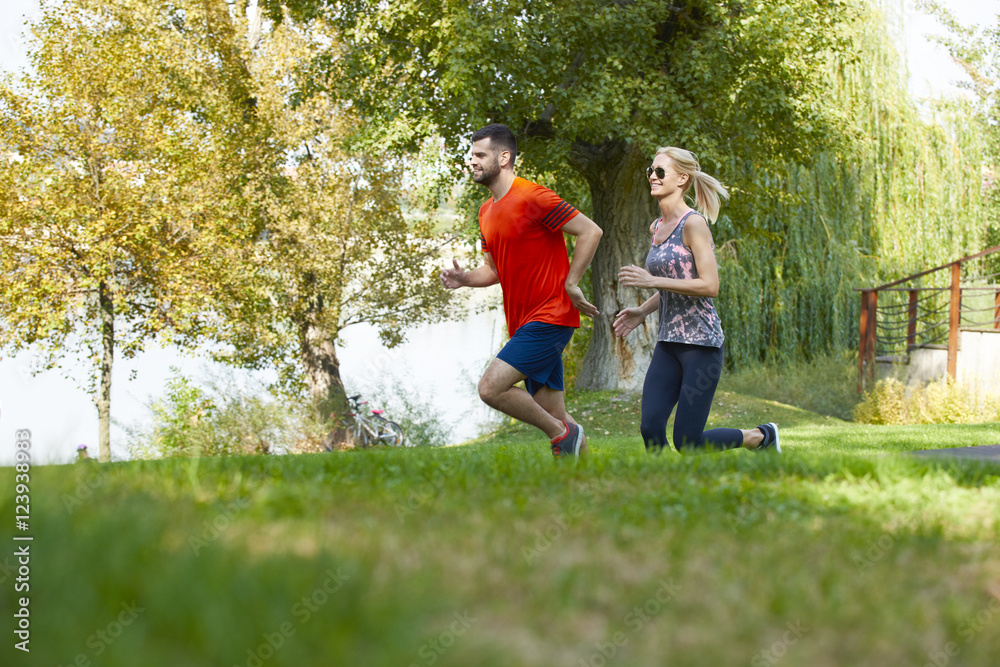 Shot of a young couple running together outdoor in the park. Shot of a young couple running together outdoor in the park.