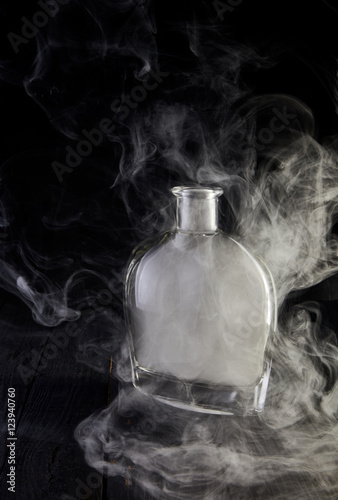 Empty decanter with smoke on black background