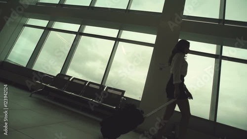 Wallpaper Mural Woman in heels goes at airport and roll suitcase on wheels. in slow motion Torontodigital.ca