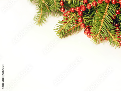 New Year background. Red balls and beads on a spruce. Decorated Christmas Tree on white.