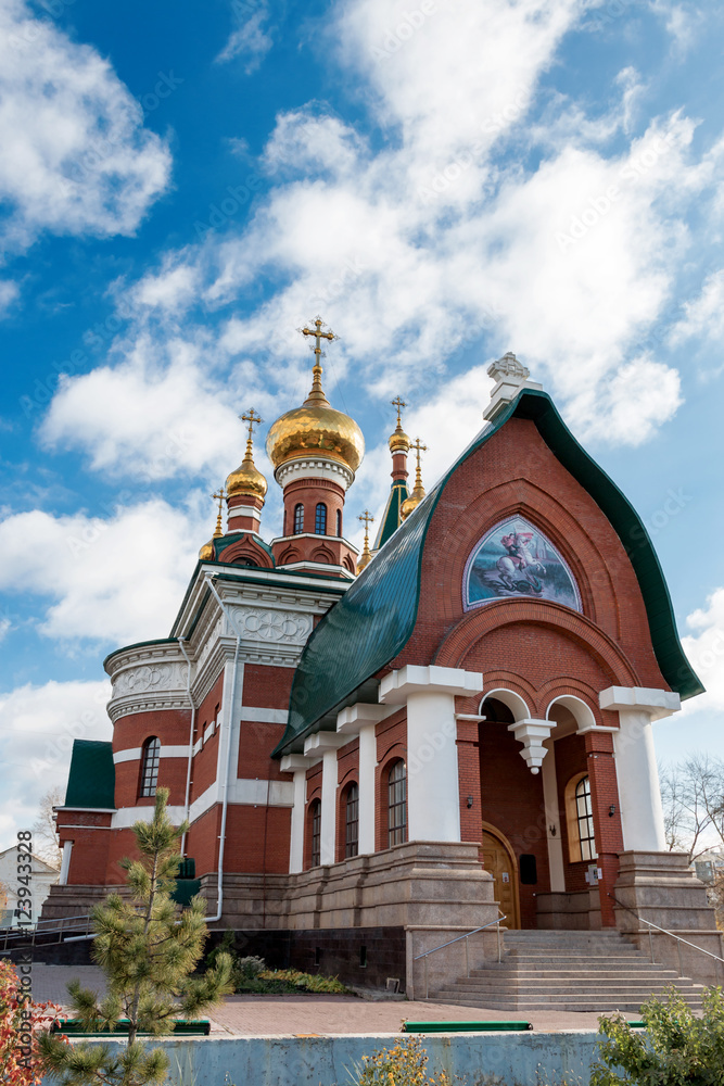 Orthodox church from a red brick against the blue sky