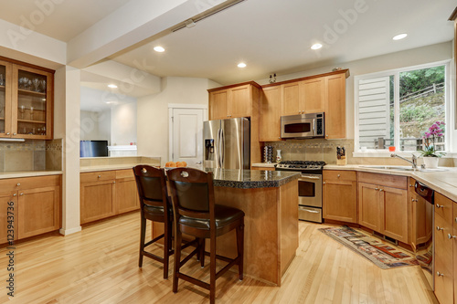 Bright wooden kitchen room with stainless steel appliances