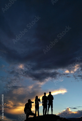 Photographers taking pictures of the sunset on top of a mountain