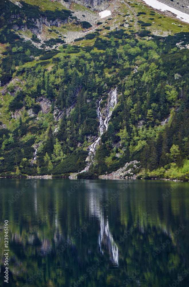 Mountain waterfall and Lake Morskie Oko in the Tatra Mountains in Poland