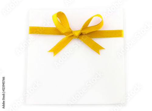 Sheet with yellow holiday bow on white background