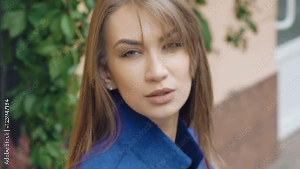 Young woman in sunglasses looking seriously at camera outdoor. Slowly Young woman in sunglasses looking seriously at camera outdoor. Slowly