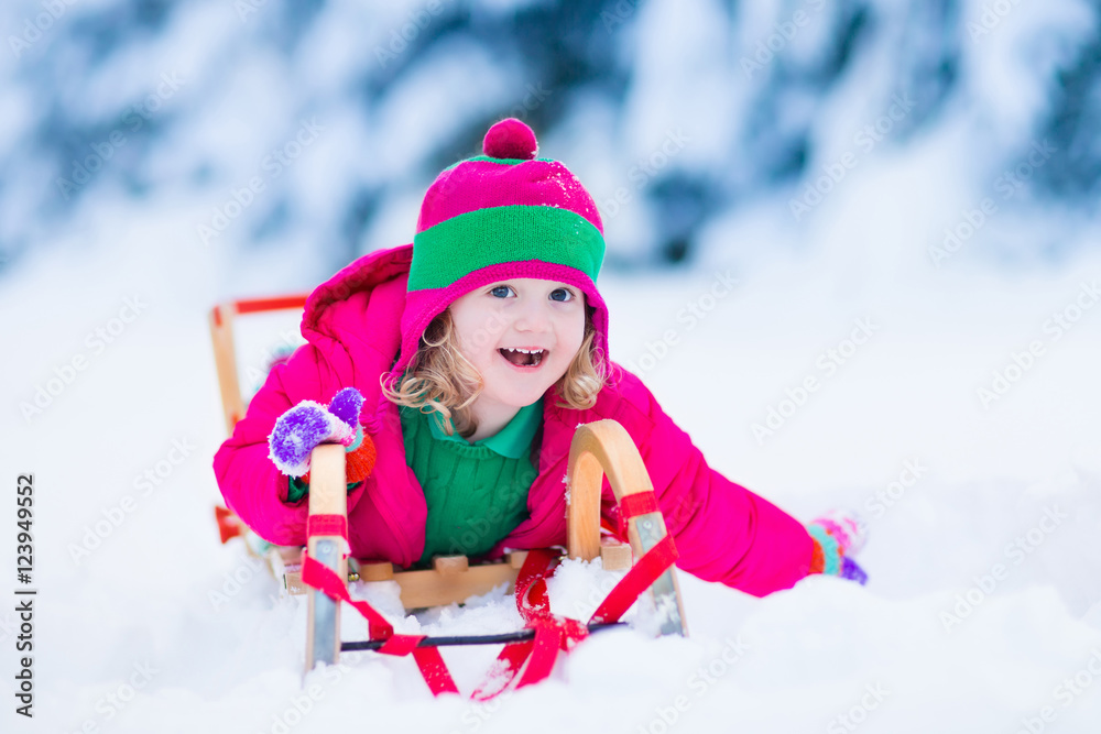 Little girl enjoying a sleigh ride in winter