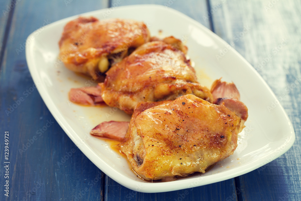 fried chicken with smoked meat on white plate on wooden background fried chicken with smoked meat on white plate on wooden background
