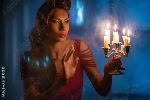 Woman looking on red candles in the fabulous night © alexydance