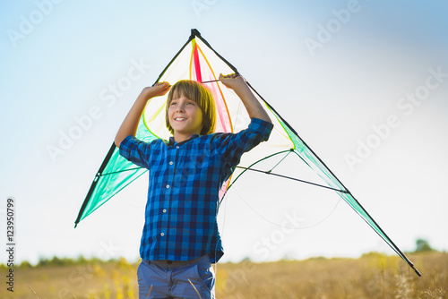 Happy and smiling boy playingin with kite outdoor photo