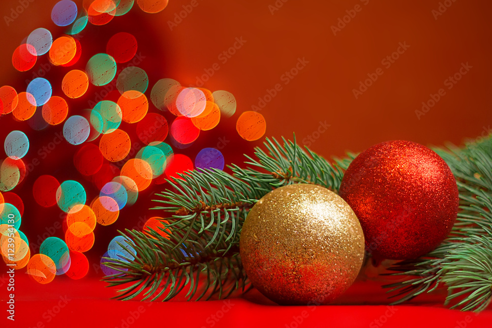 Christmas-tree branch with red and gold balls on a motley blurred background. New year's 2017 lights. Decoration of greeting card. Christmas-tree branch with red and gold balls on a motley blurred background. New year's 2017 lights. Decoration of greeting card.