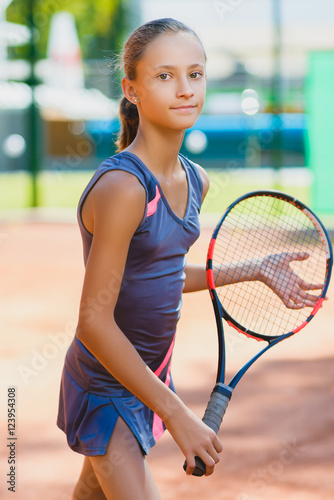 Cute girl playing tennis and posing in court indoor © dreamsnavigator