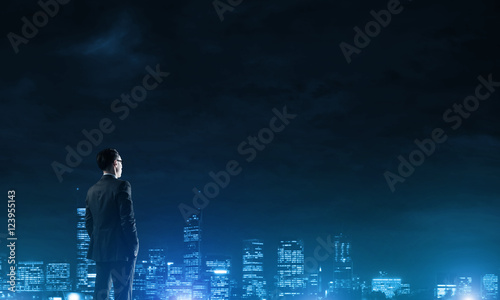 Businessman viewing night glowing city © adam121