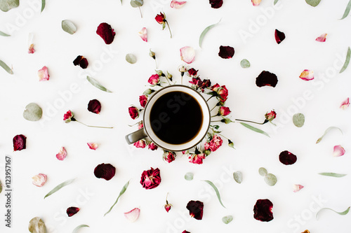 Fototapeta samoprzylepna czarny kubek kawy i bukiet czerwonych pąków róży z eukaliptusa na białym tle. leżał płasko, widok z góry