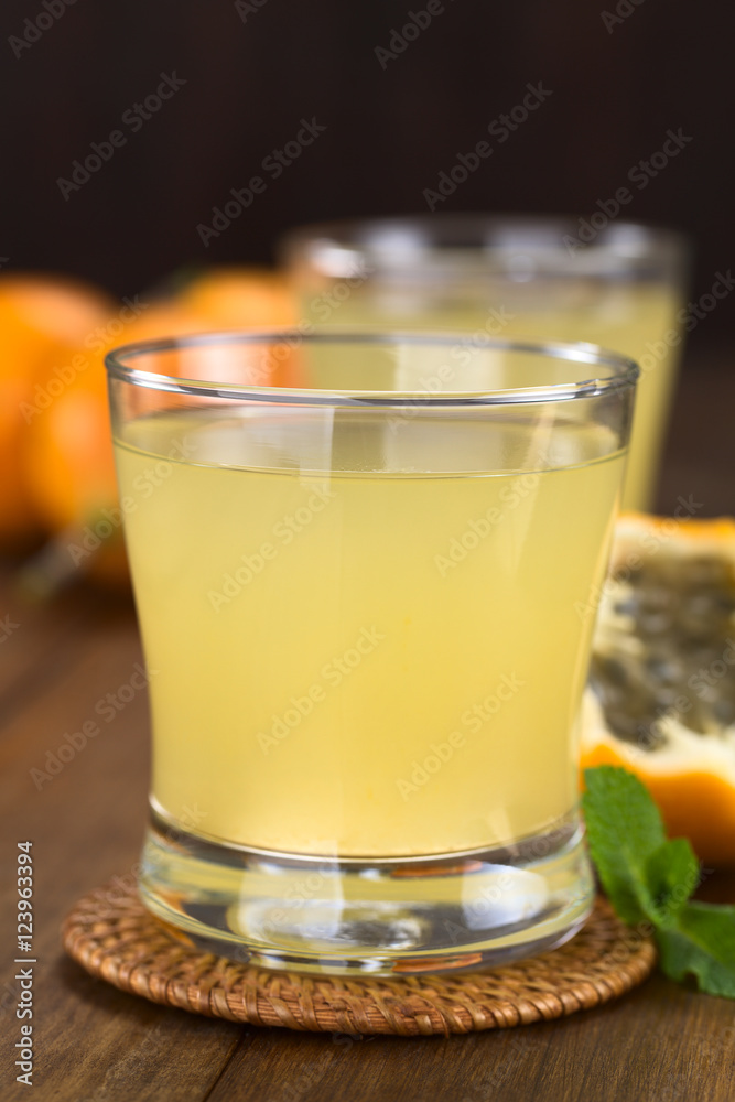 Frischer Saft aus süßer Granadilla (lat. Passiflora ligularis) (Selektiver Fokus, Fokus auf den vorderen Glasrand) Frischer Saft aus süßer Granadilla (lat. Passiflora ligularis) (Selektiver Fokus, Fokus auf den vorderen Glasrand)