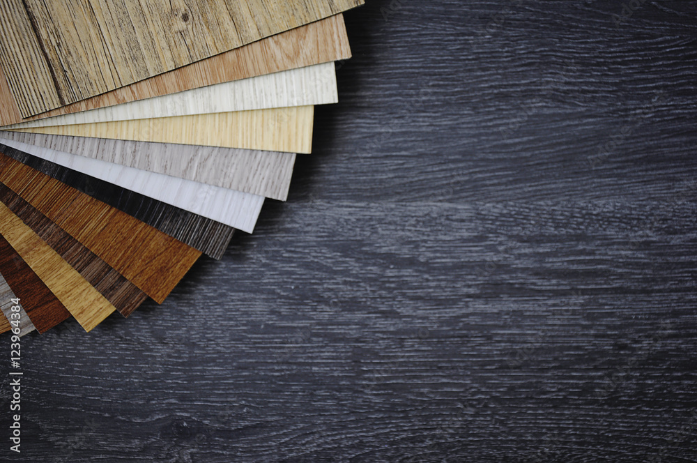 Laminate Wood Concept - Sample pack of wooden flooring laminate on wooden black floor - obrazy, fototapety, plakaty 