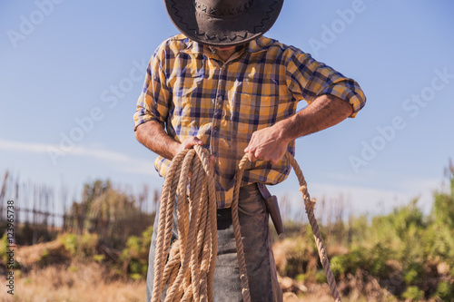 cowboy picking up a rope in the field photo