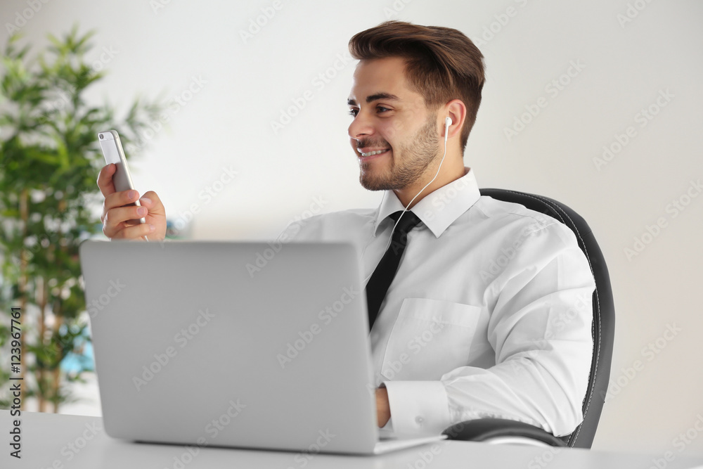 Handsome young man using cellphone at office Handsome young man using cellphone at office