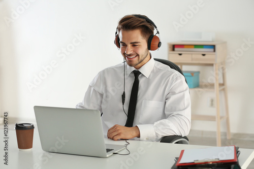 Handsome man listening to music with headphones at office