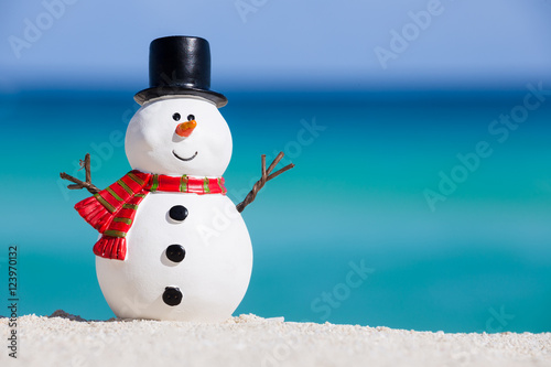 Snowman toy at white sandy beach