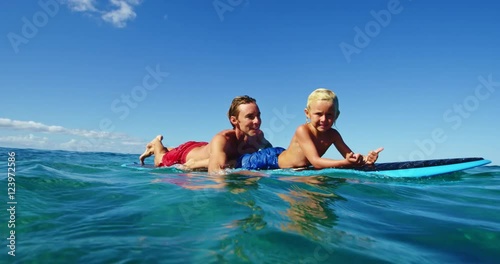 Father and son having fun surfing together, summer lifestyle family time