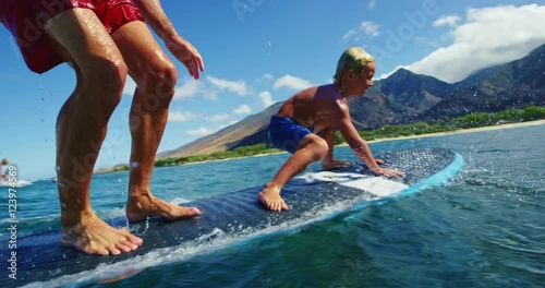 Father and son having fun surfing together, summer lifestyle family time