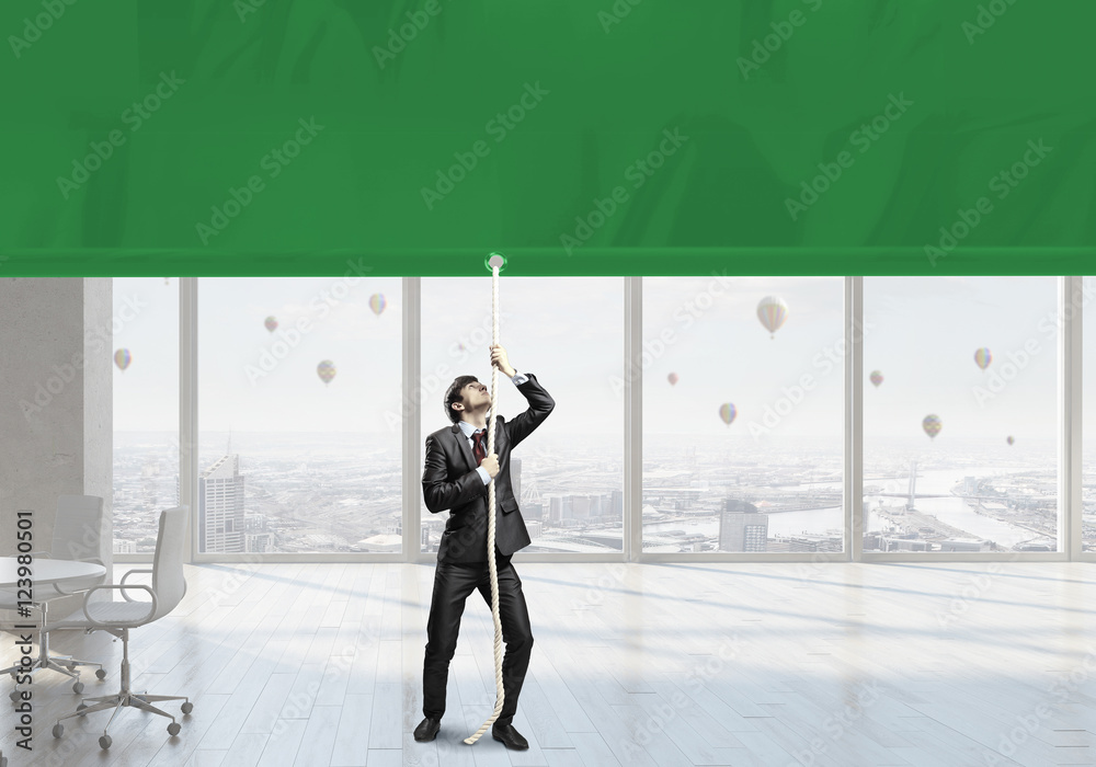 Fototapeta premium Businessman pulling banner . Mixed media