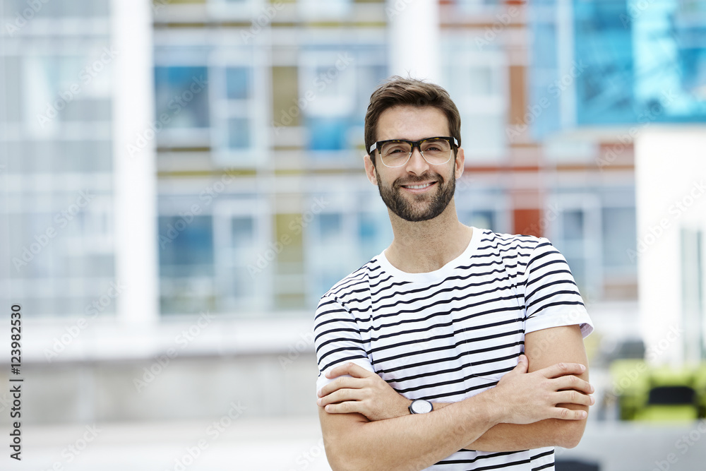 Bespectacled and confident man in striped t-shirt