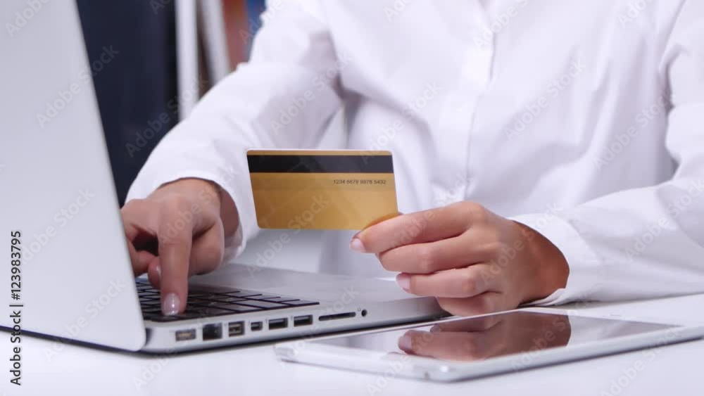 Girl doing online shopping in office in front of laptop. Close up Girl doing online shopping in office in front of laptop. Close up