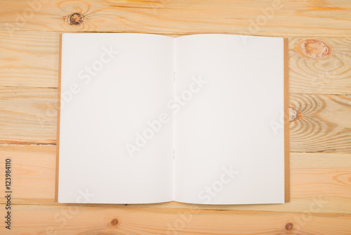 Open new white notebook on the wood background.