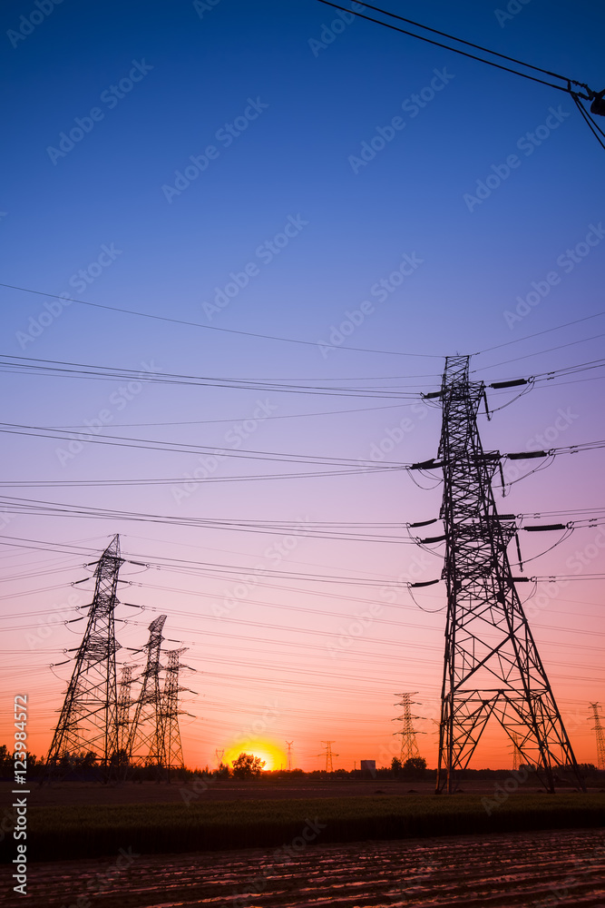 The silhouette of the evening electricity transmission pylon