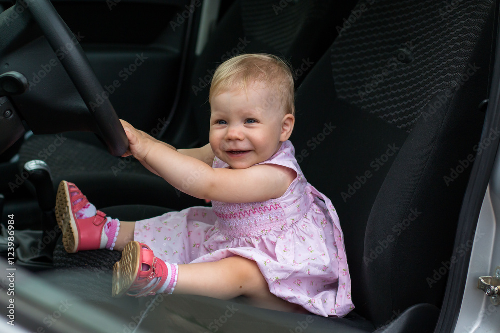 Small cute baby in a car in a warm day