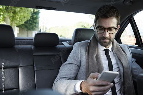 Businessman texting on smartphone in car © sanneberg