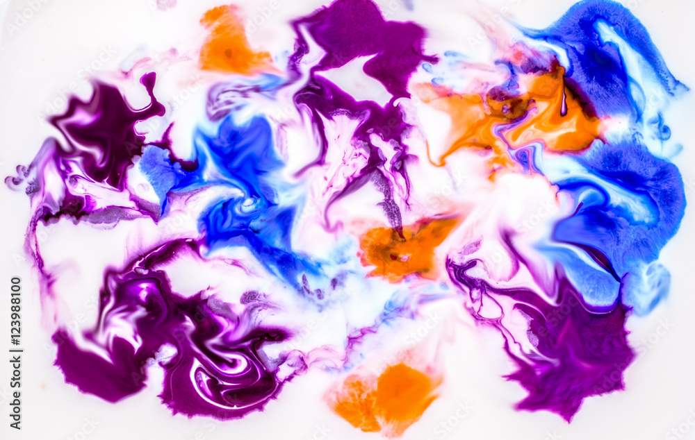 Blue purple and orange ink flowing and mixing in milk texture