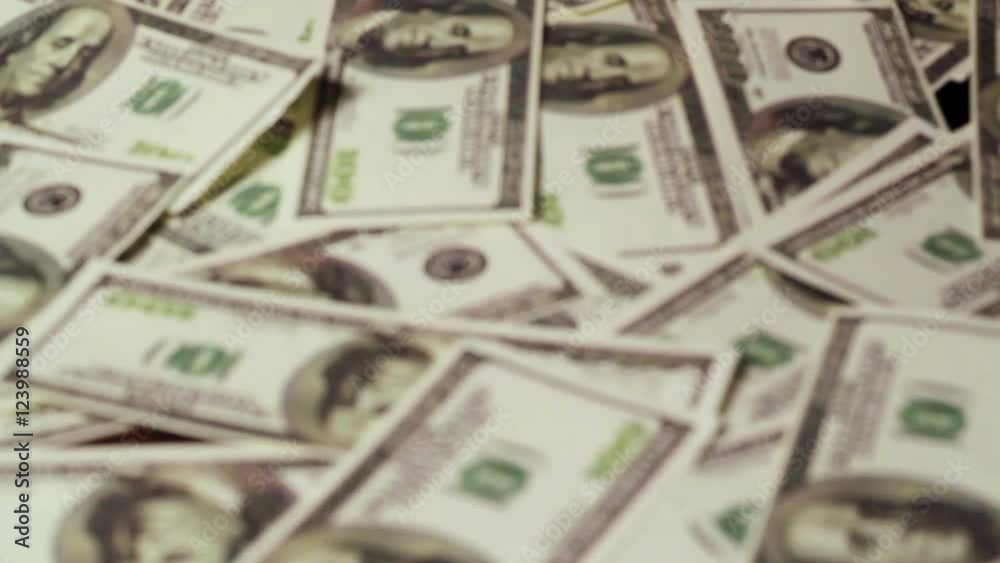 The dollars are falling on the background of hundred dollar bills.Us dollars. The dollars are falling on the background of hundred dollar bills.Us dollars.