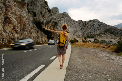Girl hitchhiking with thumb up