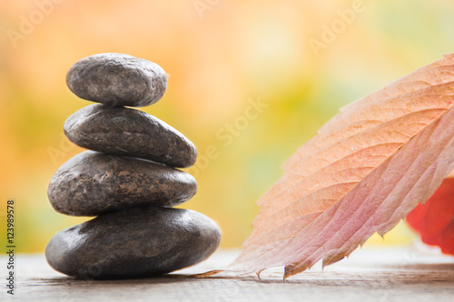 Stones spa with autumn leaves on the blurred background. Zen like concepts.