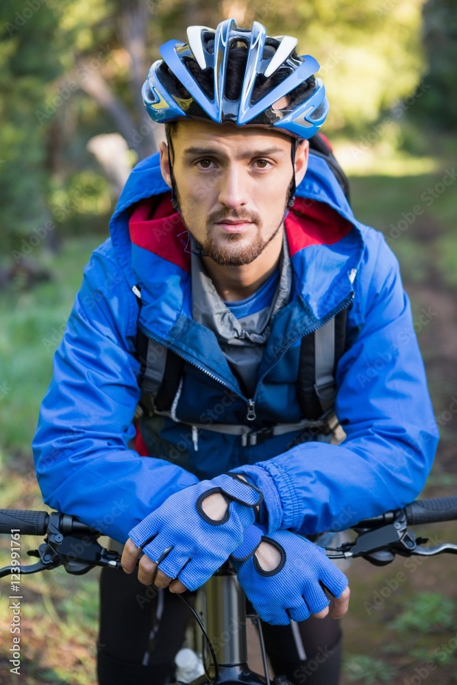 Portrait of male mountain biker with bicycle in the forest Portrait of male mountain biker with bicycle in the forest