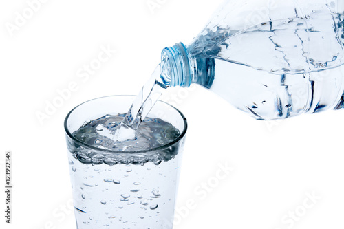 Filling glass with water from plastic bottle