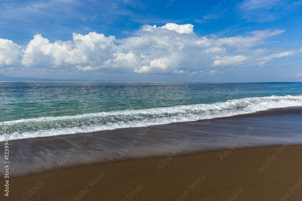 Black volcanic sand beach in Bali Island Indonesia