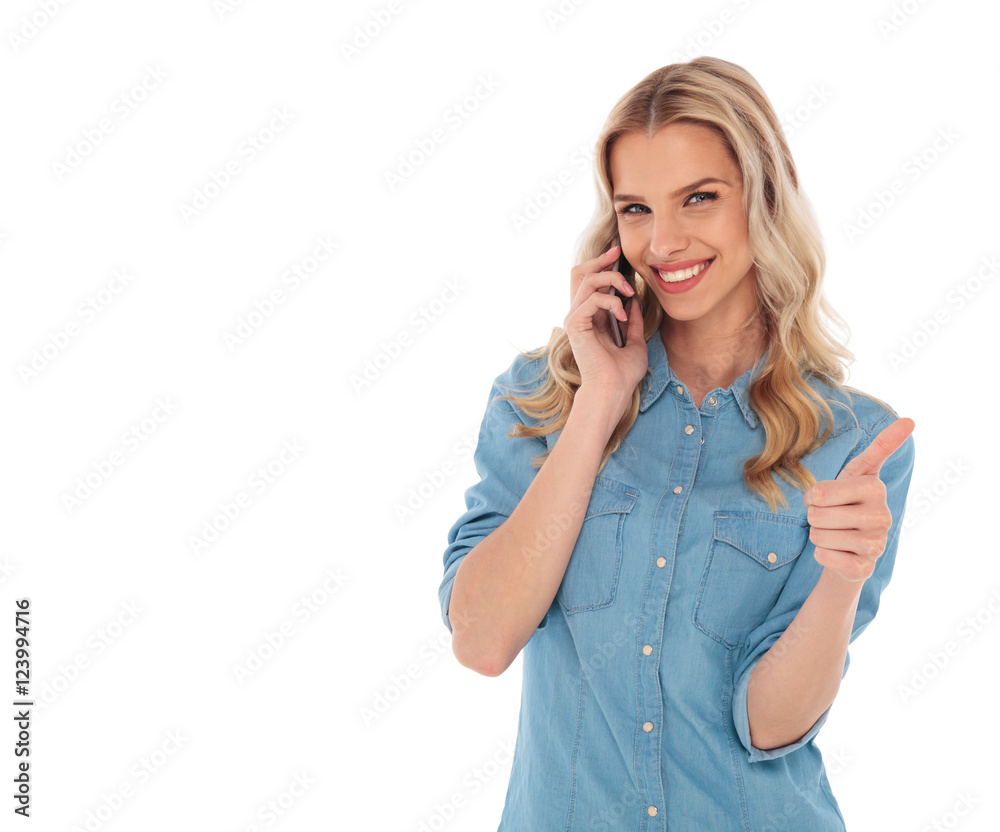 blonde woman making the ok sign while talking on phone blonde woman making the ok sign while talking on phone