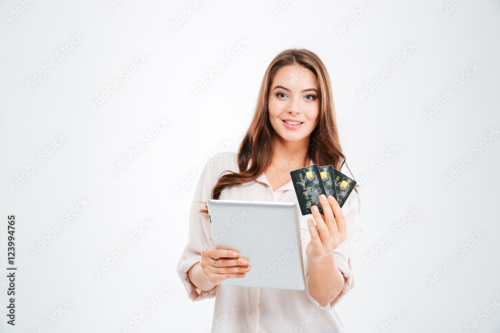 Smiling young woman holding bank card and tablet computer Smiling young woman holding bank card and tablet computer
