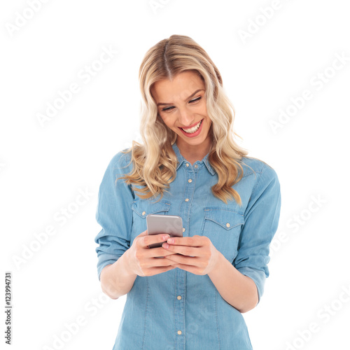 laughing blonde woman reading good news on her phone