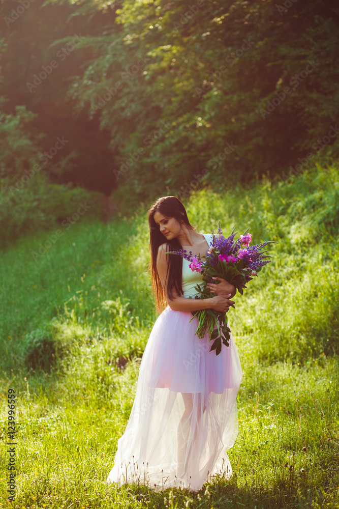 girl with beautiful flowers walks in the woods girl with beautiful flowers walks in the woods