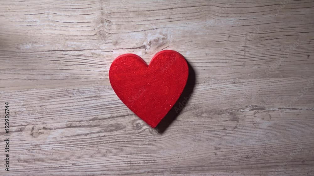 Girl placing red heart on a wooden table, view from above. Solitude, love, Valentine's day concepts. 4K video Girl placing red heart on a wooden table, view from above. Solitude, love, Valentine's day concepts. 4K video