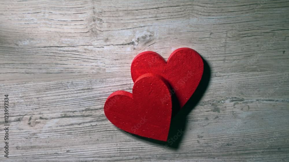 Girl placing two red hearts on a wooden table, top view. Romance, love, Valentine's day, relationship concepts. 4K video Girl placing two red hearts on a wooden table, top view. Romance, love, Valentine's day, relationship concepts. 4K video